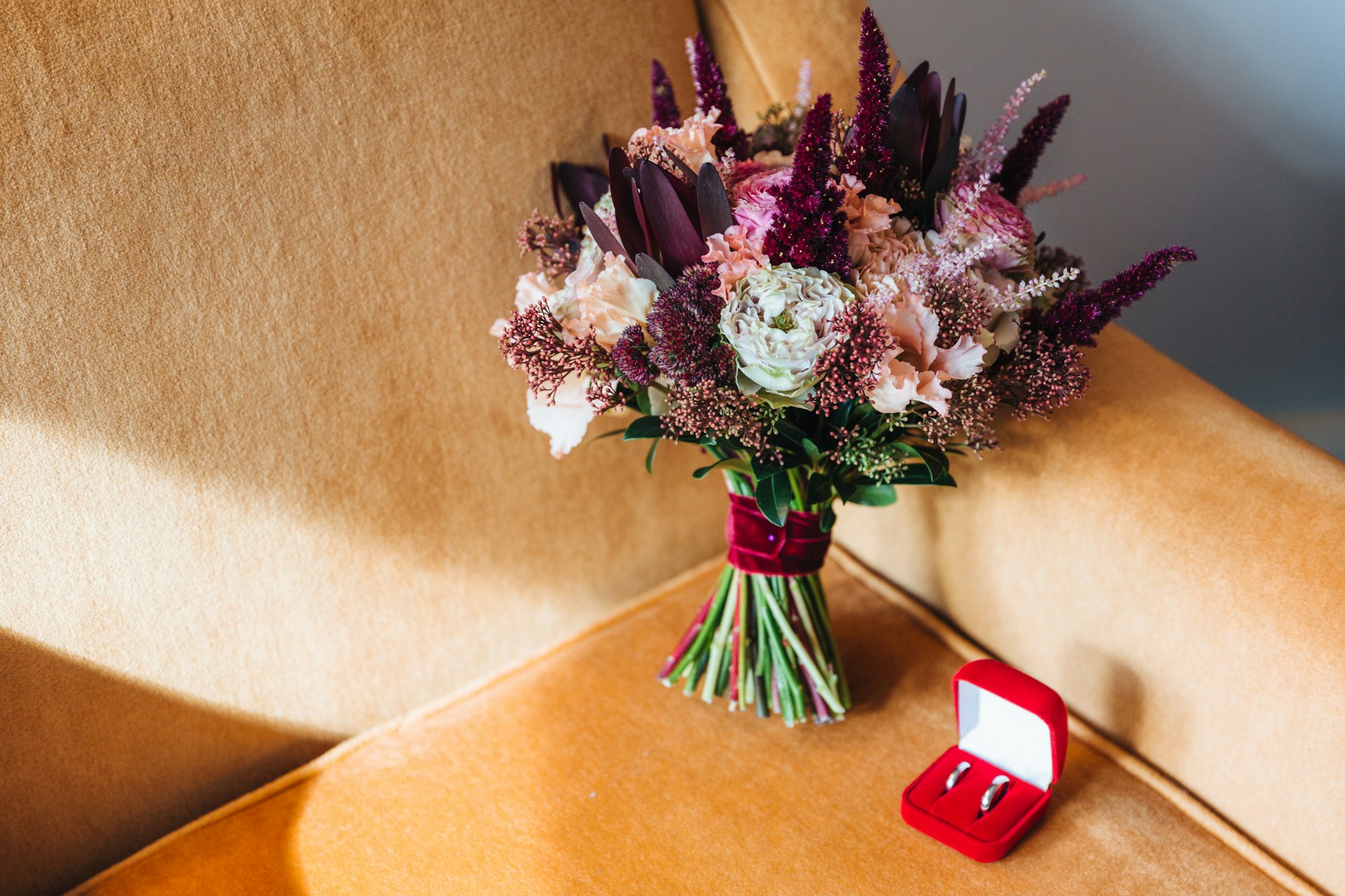 Marriage and engagement concept. Wedding rings and bouquete on armchair